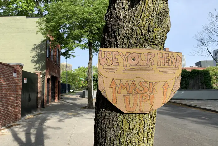 A handmade sign encourages New Yorkers to wear masks.